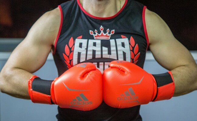 A boxer holding his gloves together in a boxing pose.