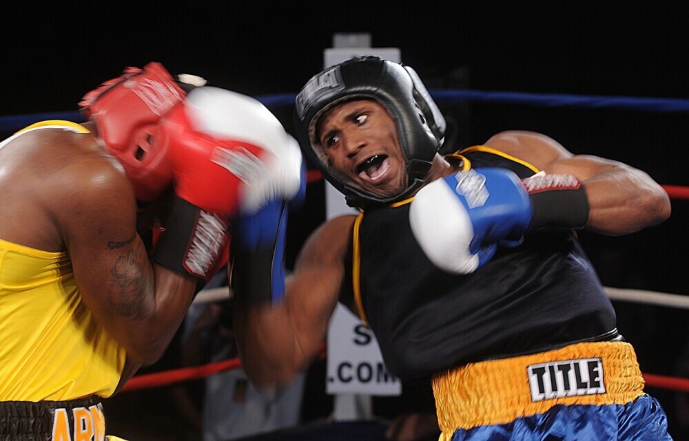 A boxer landing a powerful uppercut on an opponent with the punch connecting under the opponents chin.