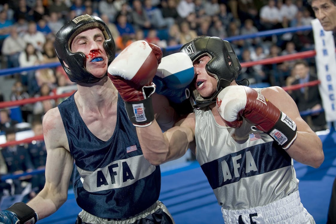 A sparring session in boxing where one fighter experiences a bleeding nose, illustrating the physical risks associated with the sport.